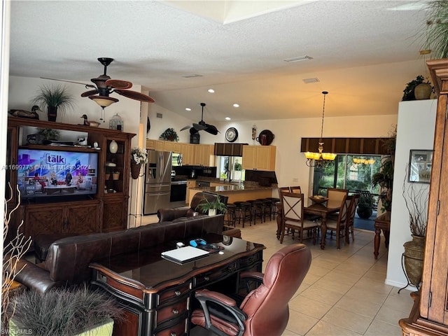 living room with light tile patterned floors, ceiling fan with notable chandelier, a textured ceiling, and vaulted ceiling