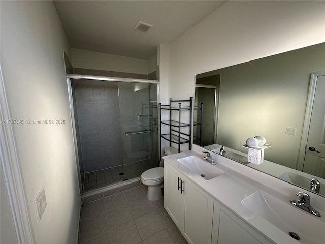 bathroom with tile patterned floors, vanity, toilet, and an enclosed shower