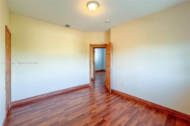 spare room with wood-type flooring and a textured ceiling