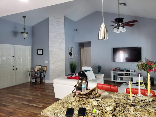 living room featuring dark hardwood / wood-style flooring, high vaulted ceiling, and ceiling fan