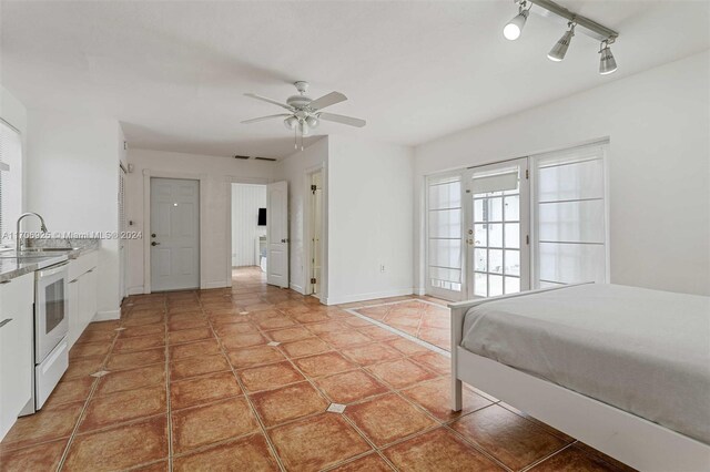 bedroom with tile patterned floors, ceiling fan, and sink