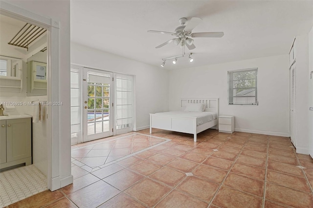 unfurnished bedroom with access to exterior, ceiling fan, light tile patterned flooring, and multiple windows