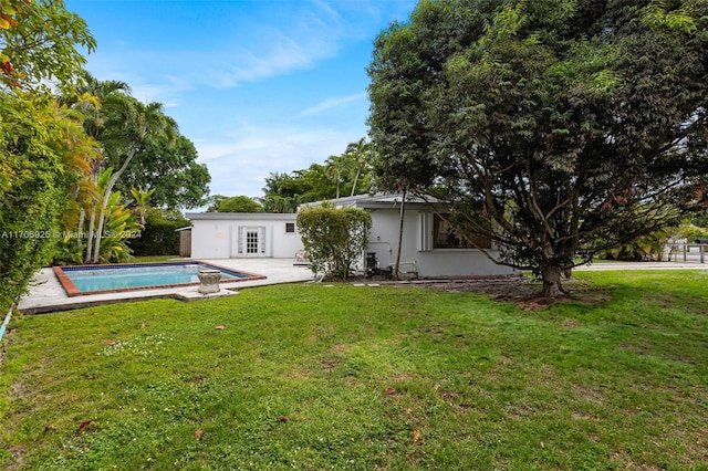 back of property with a lawn and a patio