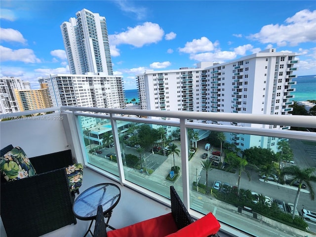 balcony with a water view and a view of city