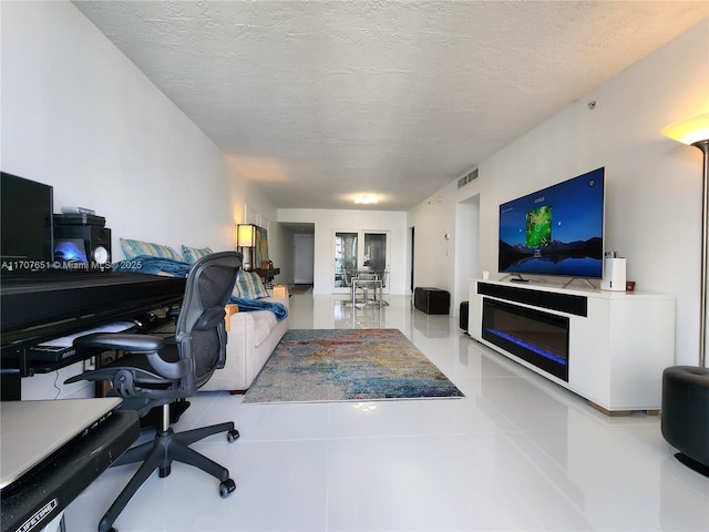 tiled office space with a textured ceiling and visible vents