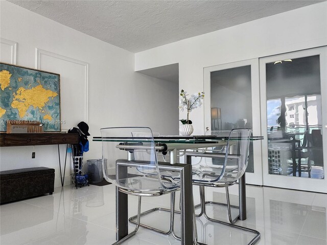 dining room featuring a textured ceiling and tile patterned flooring