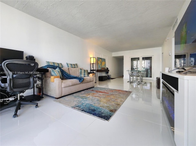 living room with tile patterned floors and a textured ceiling