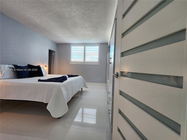 bedroom with a textured ceiling and baseboards
