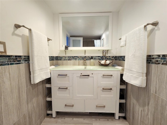 bathroom with vanity, wood-type flooring, and tile walls