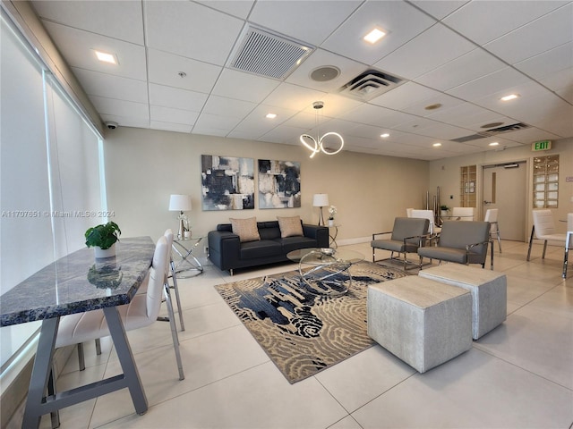 tiled living room with a paneled ceiling