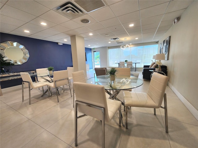 tiled dining space featuring a paneled ceiling