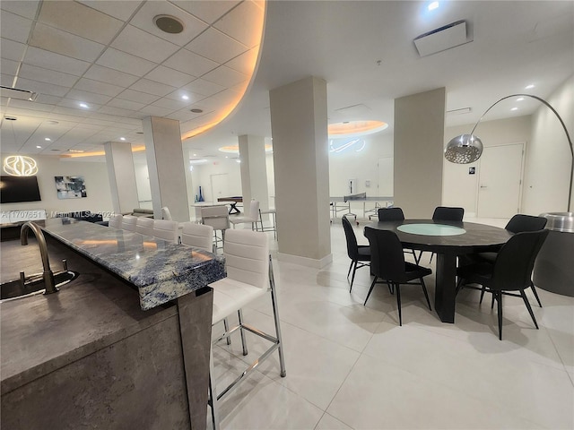 tiled dining area with a paneled ceiling