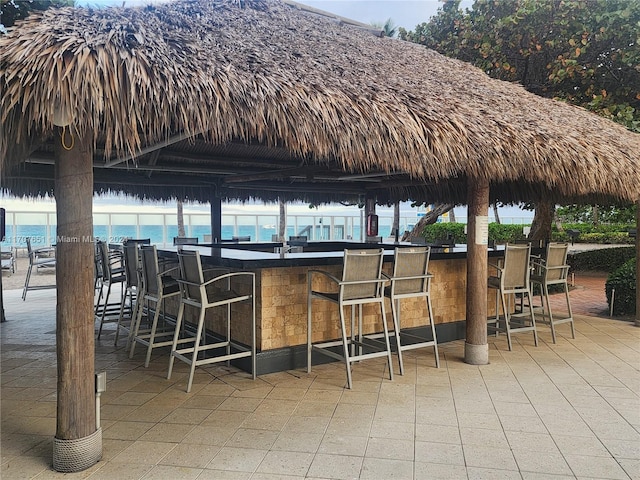 view of patio with a water view and an outdoor bar