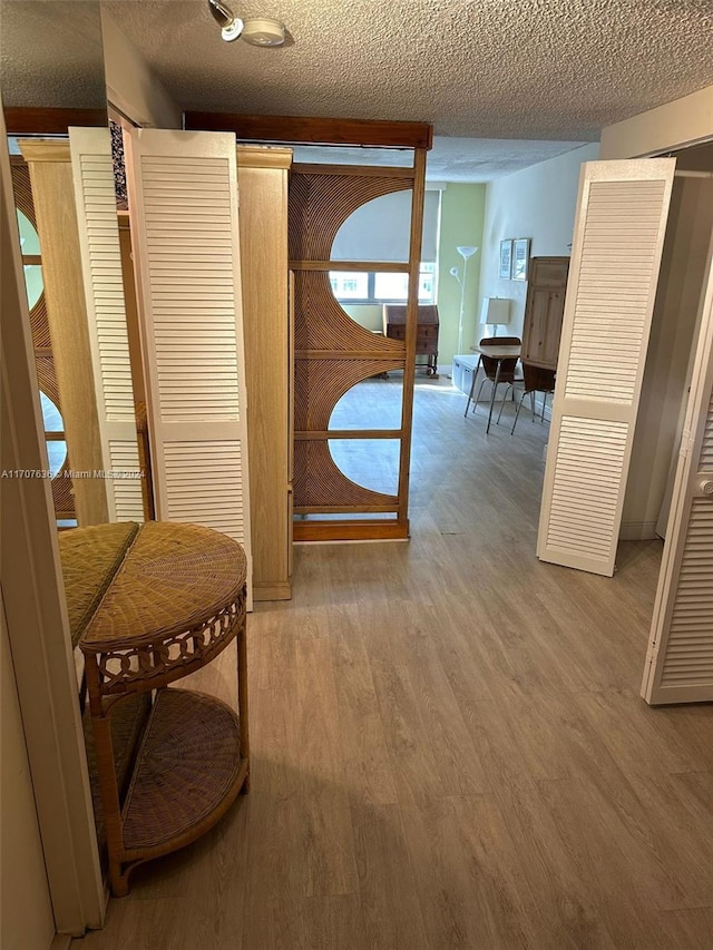 hallway featuring hardwood / wood-style flooring and a textured ceiling