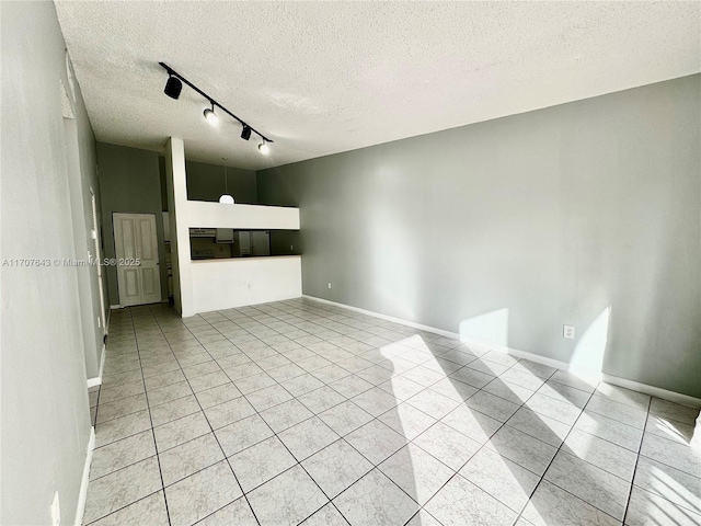 unfurnished living room with light tile patterned floors, a textured ceiling, and rail lighting