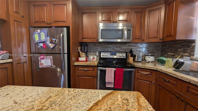 kitchen featuring decorative backsplash, light stone countertops, and stainless steel appliances