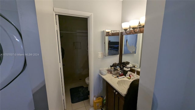 bathroom featuring tile patterned floors, vanity, toilet, and a shower