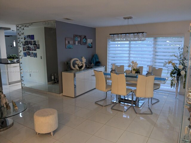 dining space with a chandelier and light tile patterned floors