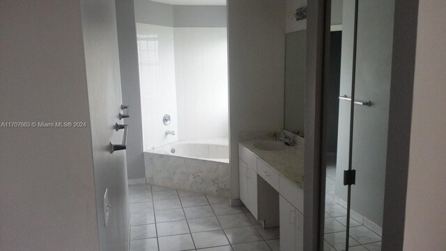 bathroom featuring tile patterned floors, tiled tub, and vanity