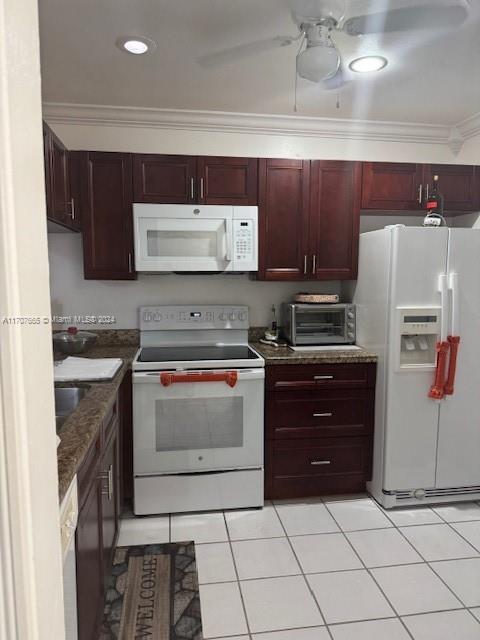 kitchen with ceiling fan, dark stone countertops, crown molding, white appliances, and light tile patterned floors