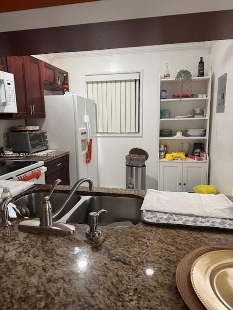 kitchen featuring dark stone countertops, white appliances, and sink