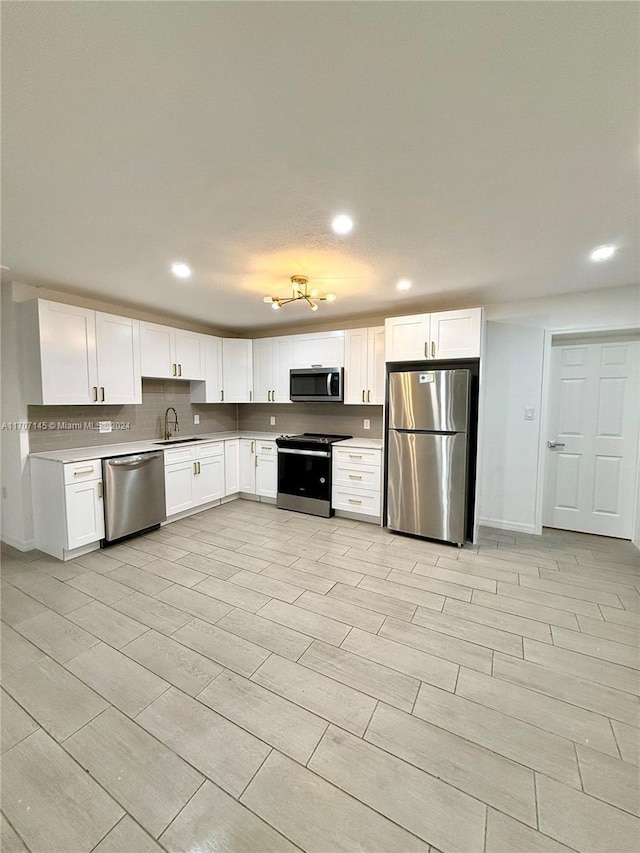 kitchen featuring white cabinets, stainless steel appliances, and sink