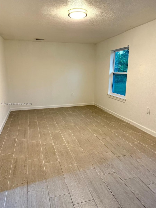 empty room featuring hardwood / wood-style floors and a textured ceiling