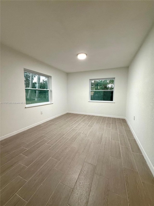 empty room with plenty of natural light and dark hardwood / wood-style floors