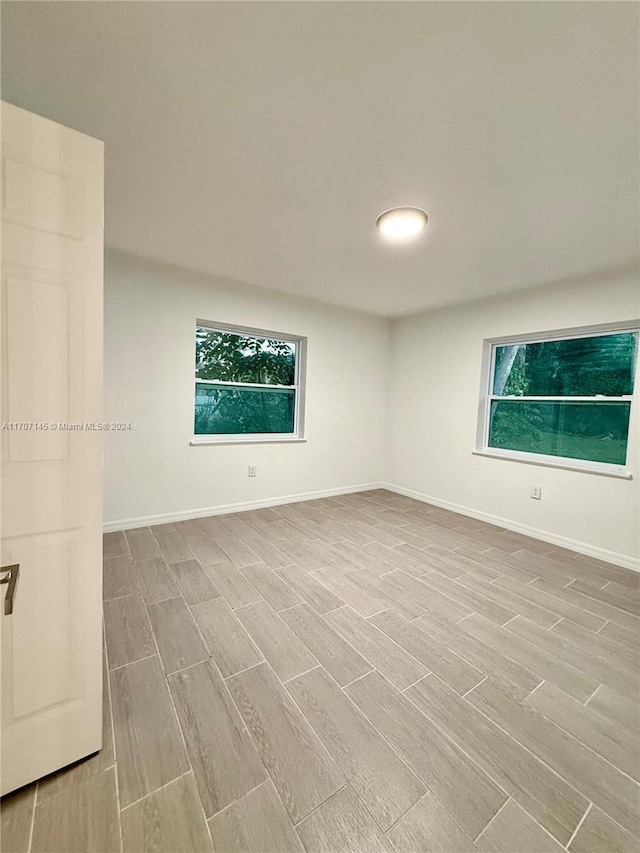 spare room with light hardwood / wood-style flooring and a healthy amount of sunlight