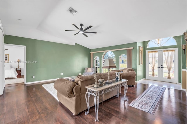 living room with french doors, ceiling fan with notable chandelier, dark hardwood / wood-style floors, and vaulted ceiling