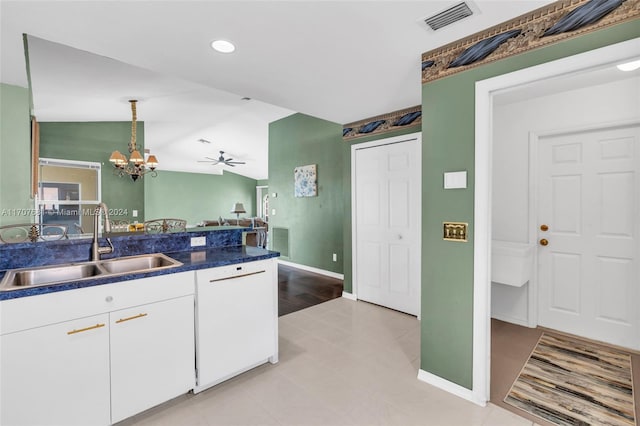 kitchen featuring white cabinetry, sink, hanging light fixtures, vaulted ceiling, and light wood-type flooring