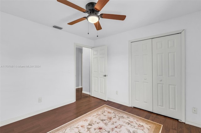 unfurnished bedroom featuring ceiling fan, dark wood-type flooring, and a closet