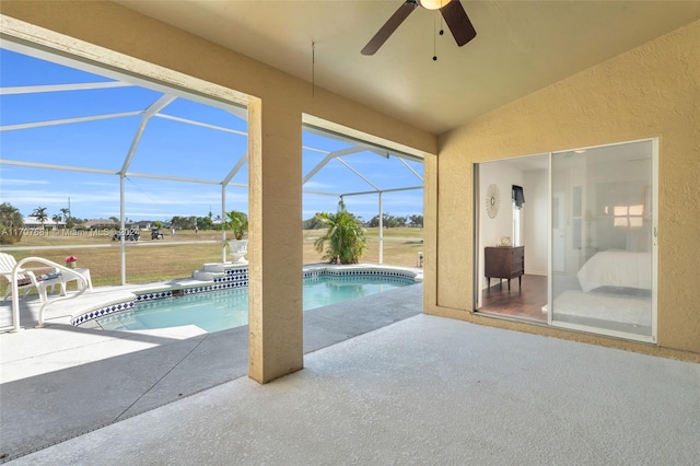 view of swimming pool featuring glass enclosure, ceiling fan, and a patio area