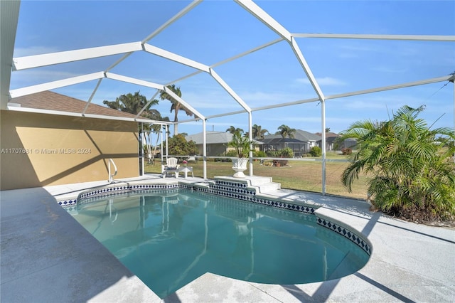 view of swimming pool featuring a lanai, a patio area, and a yard