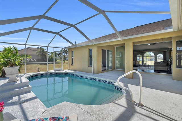 view of pool featuring a patio area, ceiling fan, and glass enclosure