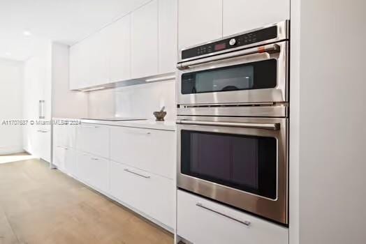 kitchen featuring white cabinetry and stainless steel double oven