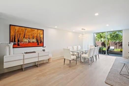 dining area featuring light hardwood / wood-style flooring and a wall of windows