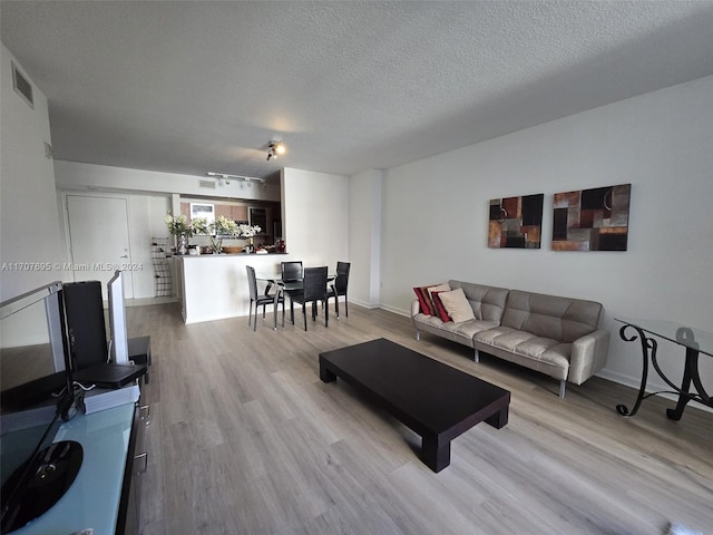 living room with light hardwood / wood-style floors and a textured ceiling