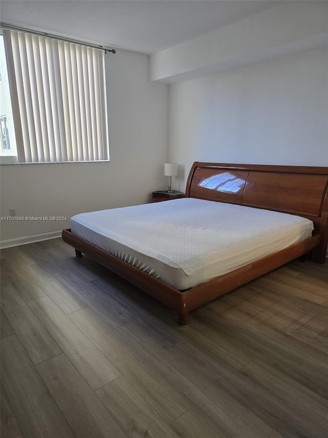 bedroom with dark hardwood / wood-style flooring