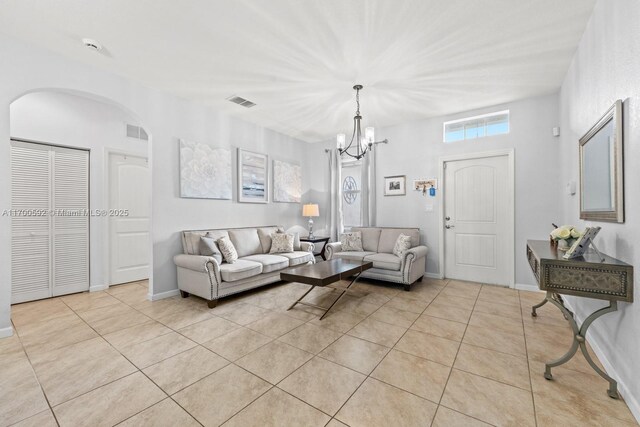 living room with light tile patterned floors and a chandelier