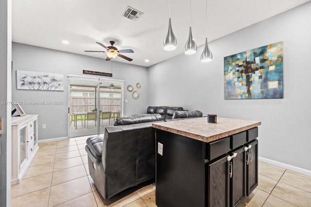 kitchen featuring baseboards, visible vents, hanging light fixtures, light countertops, and light tile patterned flooring