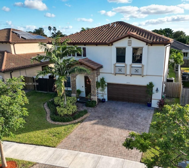 mediterranean / spanish-style house featuring a garage and a front yard