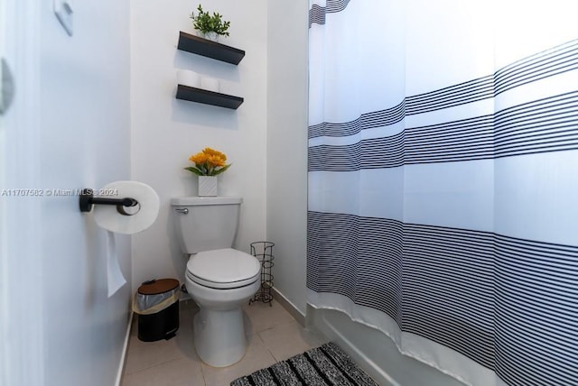 bathroom with a shower with shower curtain, tile patterned flooring, and toilet