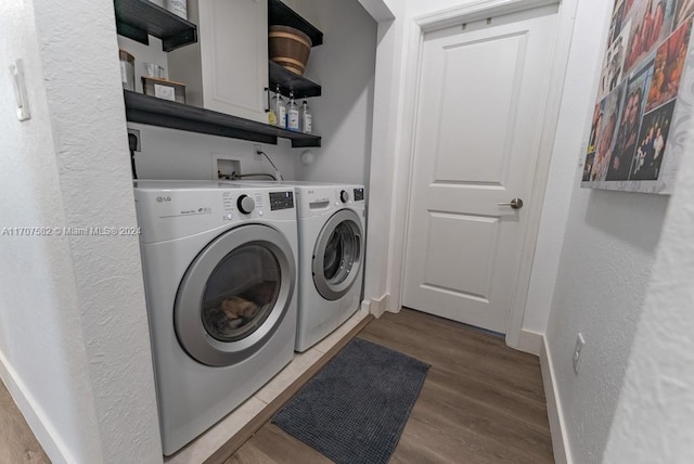 washroom with separate washer and dryer and wood-type flooring