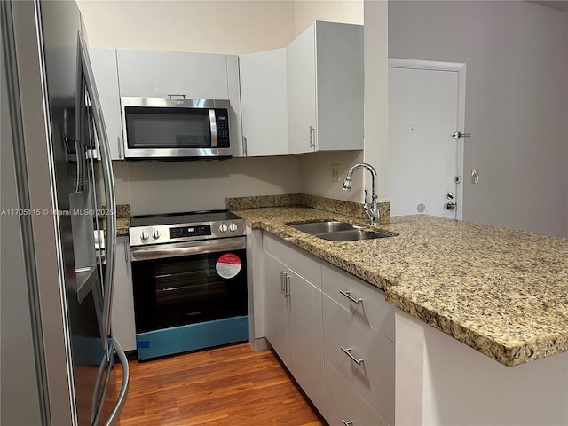 kitchen featuring white cabinets, stainless steel appliances, light hardwood / wood-style flooring, and sink