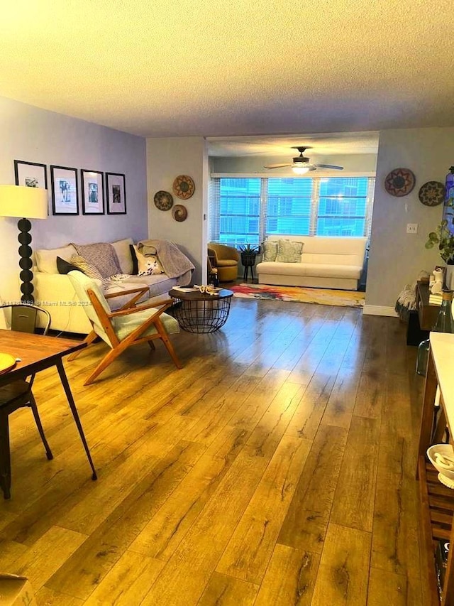 living room with ceiling fan, hardwood / wood-style floors, and a textured ceiling