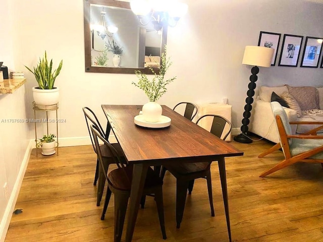 dining area featuring a notable chandelier and wood-type flooring