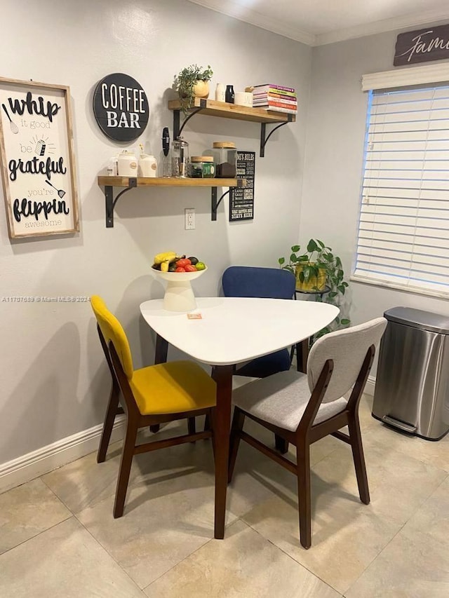 dining area with light tile patterned floors and crown molding