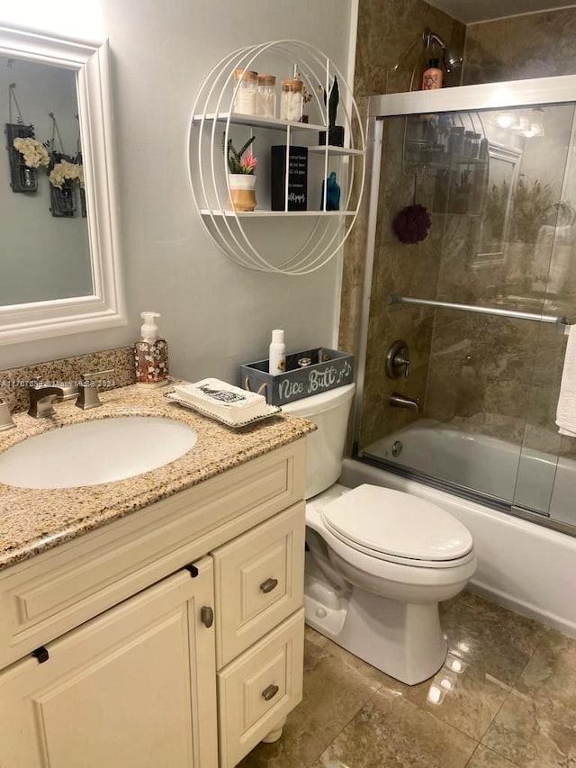 full bathroom with shower / bath combination with glass door, vanity, and toilet