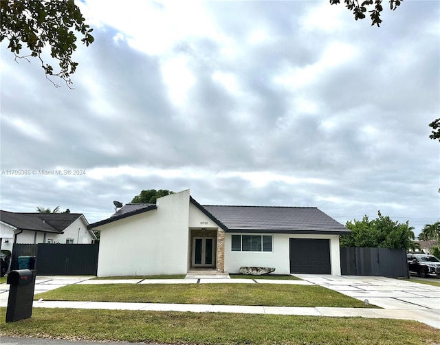 view of front of property featuring a front yard and a garage